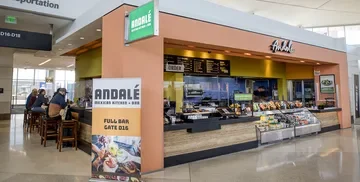 View of Andale in Terminal 2, showing people seated at bar area, ordering counter, and grab -and-go items