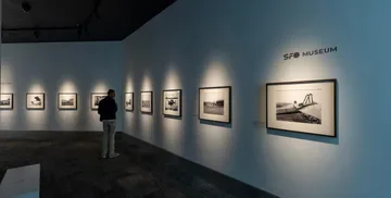 A guest looking at a photograph in an SFO Museum exhibition