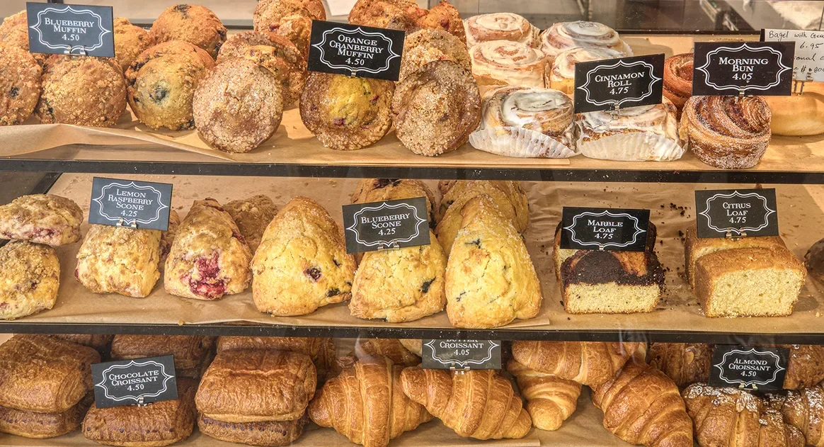 Pastry case of scones, loaf cakes, muffins, and croissants at Little Skillet