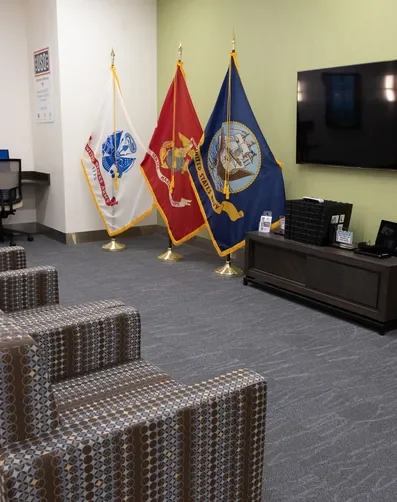 TV room at USO Center at SFO with seating and flags