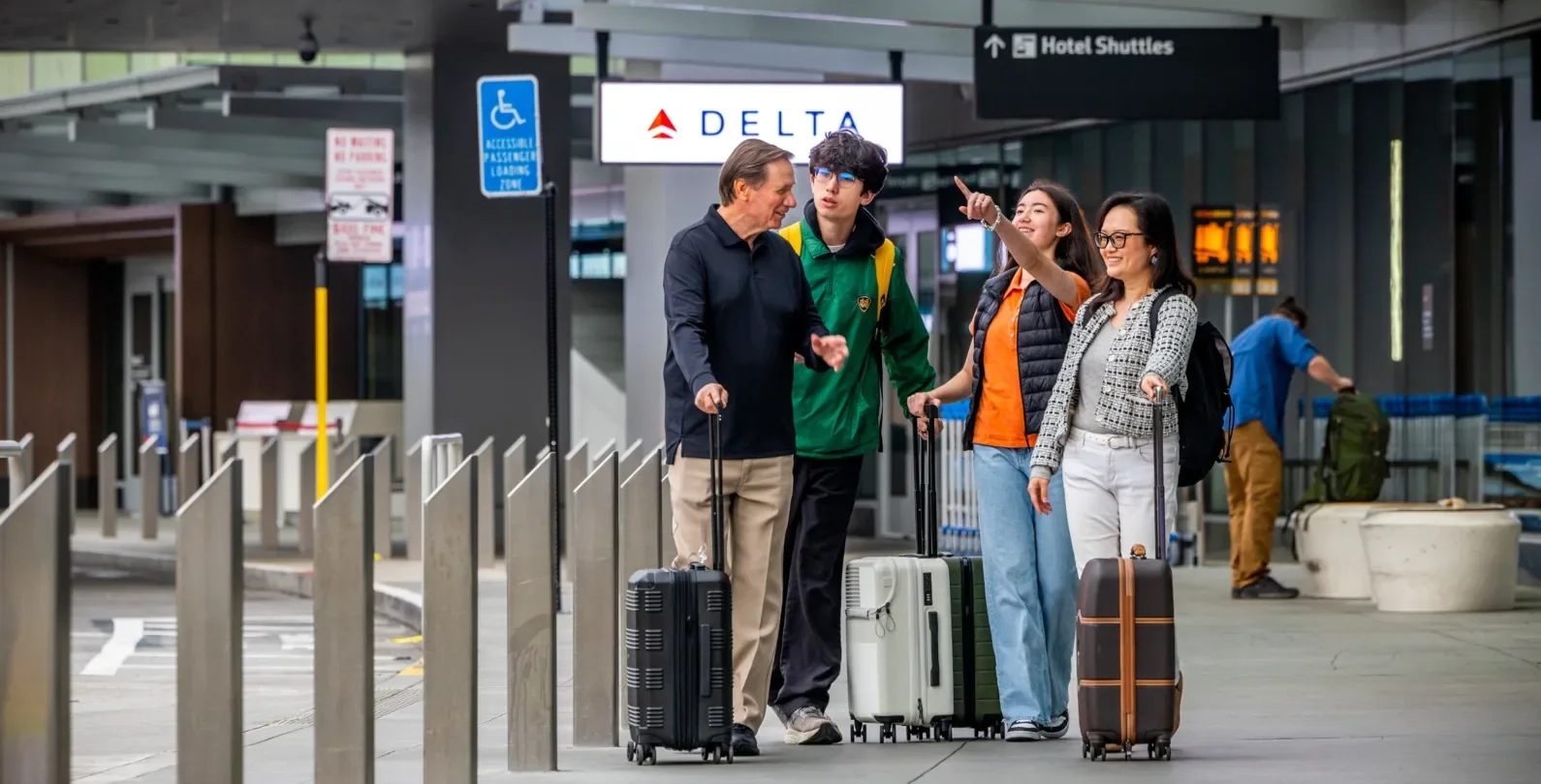 A group of four passengers on the Departures curb of SFO