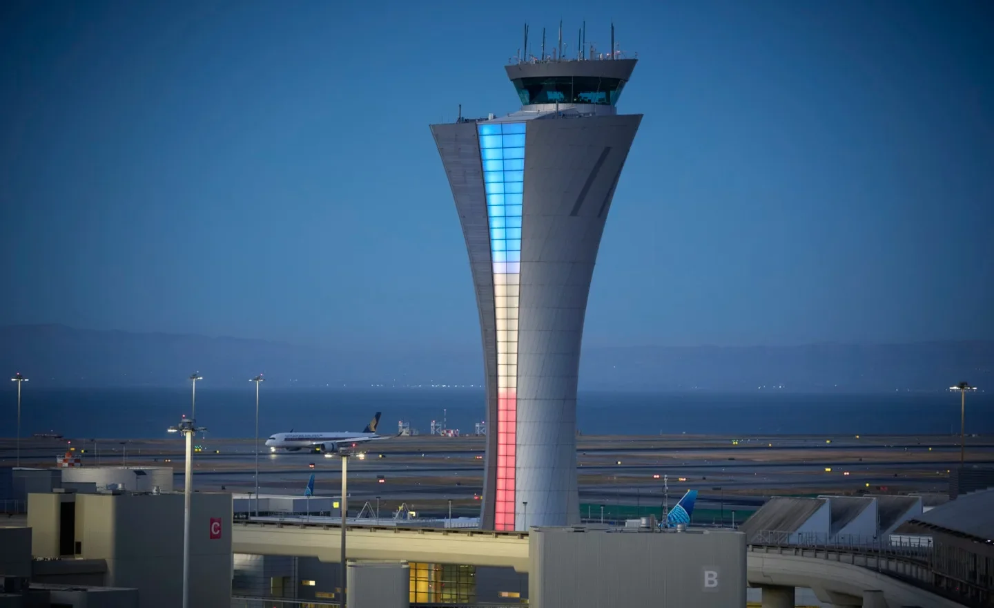 The Air Traffic Control Tower at SFO lit up in red, white, and blue colors