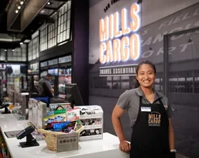 Employee posing at the register of Mills Cargo