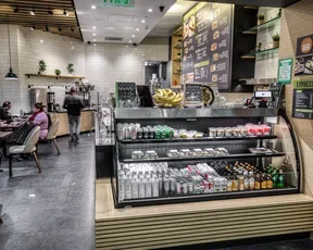 Asian Box's Grab-and-Go case, featuring pre-packaged food and beverages. Seated customers are in the background.
