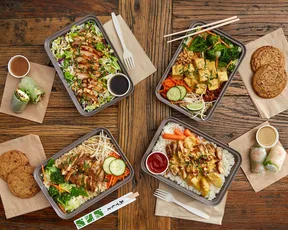 Four entree boxes with sides (salad, curry, noodle and rice box) illustrating a variety of meal options at Asian Box.